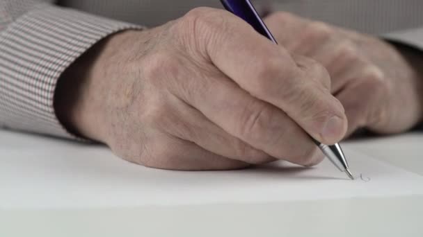 Man with wrinkled hands in shirt writes accurately with pen — Stock Video