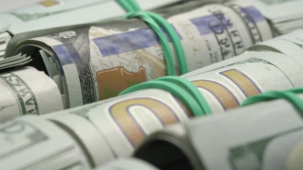 Motion past rolled dollar bills with rubber bands closeup — Stock Video