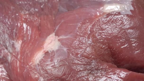 Камера переворачивает свежее мясо свинины при ярком светлом макросе — стоковое видео