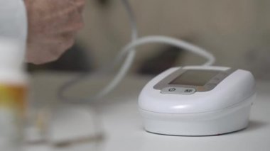 Emekli, dijital tansiyon monitöründe düğmeye basıyor