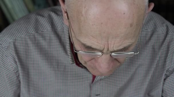 Senior man bär glasögon och skjorta sätter piller i munnen — Stockvideo