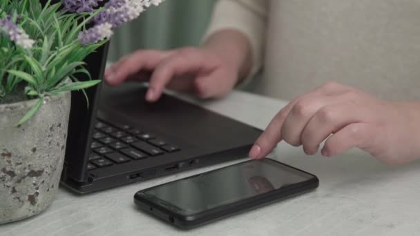 Lady hand with manicure counts on modern smartphone at table — Stock Video