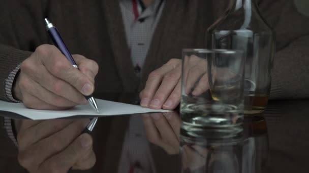 Idősebb ember ráncos kezek írni papírlapra tollal — Stock videók