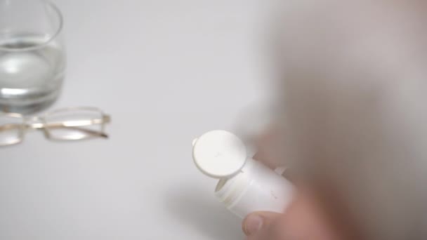 Homem sênior com óculos derrama pílulas na mesa vista de perto — Vídeo de Stock
