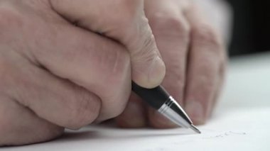 Konsantre kıdemli adam kalemle özel mektup yazar.