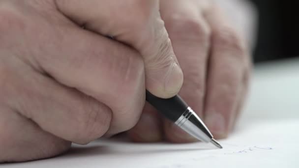 Koncentrerad senior man skriver privat brev med penna — Stockvideo
