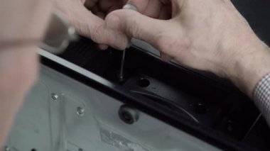Kıdemli mühendis modası geçmiş televizyonun siyah kapağını beceriyor