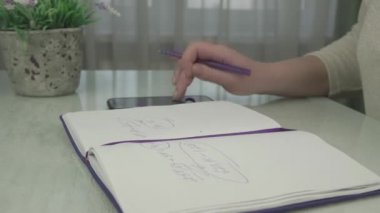 İş kadını mor kalemi koyar ve defteri kapatır.