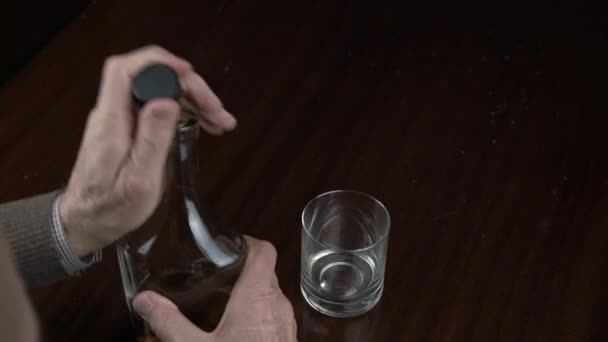 Personenhände nehmen Flasche mit Cognac und gießen ins Glas — Stockvideo