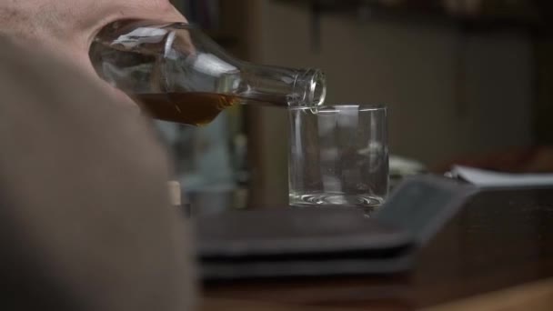Gerijpte man drinkt cognac zittend aan bruine houten tafel — Stockvideo