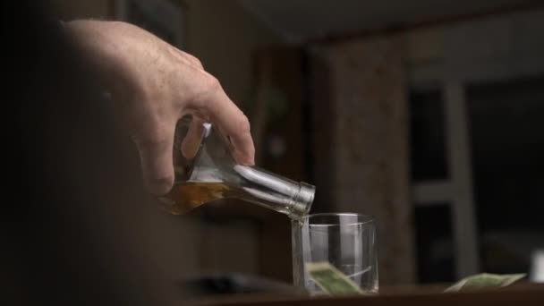 Yaşlı adam evde oturmuş içki ve alkol dolduruyor. — Stok video