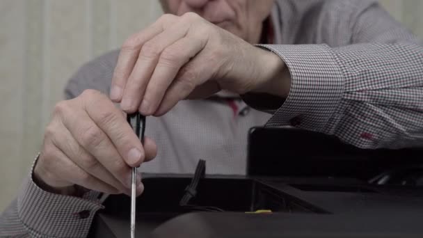 Senior důchodce opravuje zastaralé černé televizní zadní kryt — Stock video