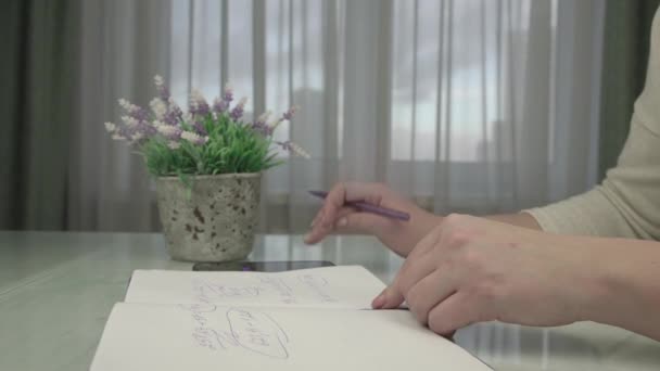 年轻女子的手与笔尖在笔记本页上写字 — 图库视频影像
