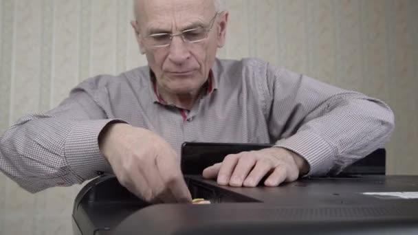 Uomo invecchiato riparazioni televisore avvitamento coperchio posteriore nero — Video Stock