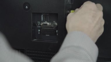 Emekli el, metal krikoları eski siyah televizyona bağlıyor