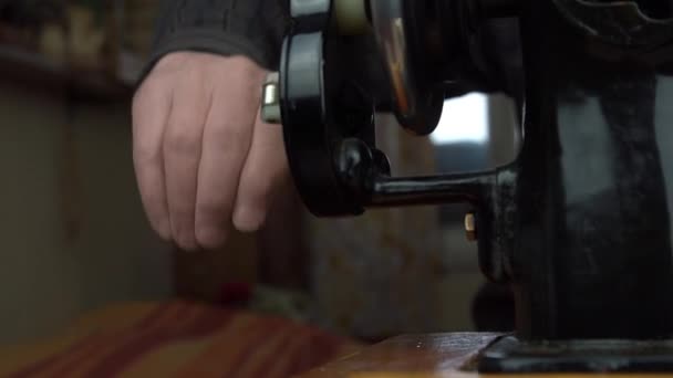 Портной поворачивает ручное колесо, расположенное на машине, для регулировки иглы — стоковое видео