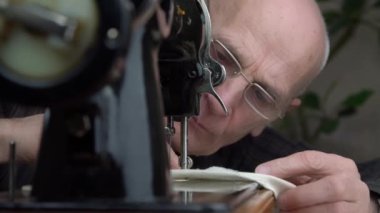 İnsan dikiş makinesinin ayağının altına sıkıştırılmış kumaşı düzeltir.