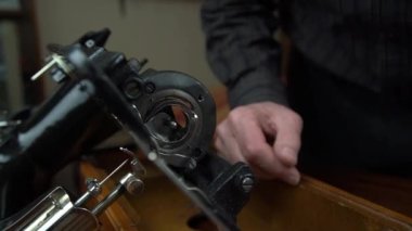 Adam eski dikiş makinesini tamir ediyor önemli parçaları onarıyor