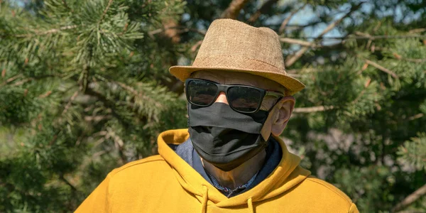 Homem idoso em óculos de sol pretos e máscara facial descartável — Fotografia de Stock