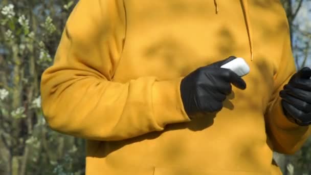 男子身披黄衣，手持耳机，特写 — 图库视频影像