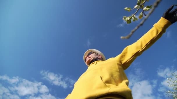Пенсионер снимает черную маску тянется к голубому небу — стоковое видео