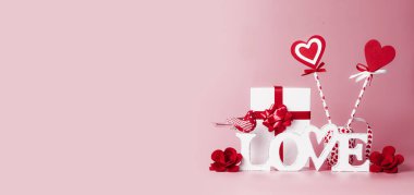 Sevgililer Günü geçmişi. Aşk kelimesi, hediye kutusu, kırmızı kurdeleler ve kalp lolipopları. Kutlama konsepti. Romantik Aşk Bildirgesi. Tasarımınız için alanı kopyalayın. Pankart.