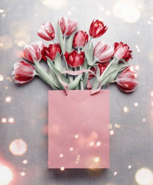 Kese kağıdındaki kırmızı laleler. Bahar çiçekleri bokeh ile doludur. Çiçek besteliyor. Bahar tatili ve selamlama konsepti