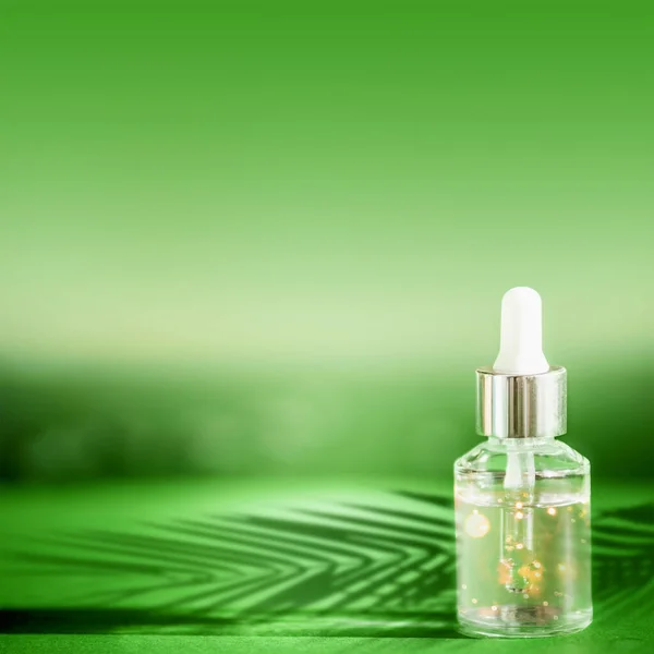 Butelka Kosmetyczna Pipetą Stojąca Zielonym Stole Cieniem Liści Palmowych Koncepcja — Zdjęcie stockowe