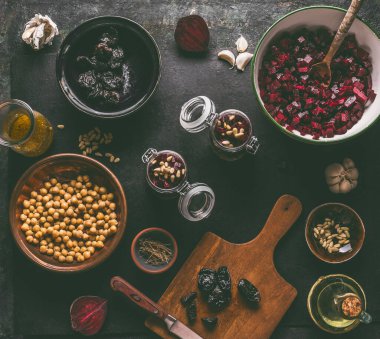 Sağlıklı vejetaryen pancar salatası hazırlama malzemeleri: koyu mutfak arka planında nohut ve çam fıstığı, üst manzara. Mor sebzeler yiyor. Temiz diyet yemekleri..