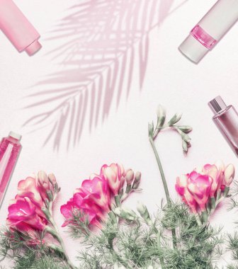 Kozmetik düz zemin, çiçekler ve arka planda palmiye yaprakları, fotokopi alanı olan üst görünüm. Pastel renk. Güzellik günlüğü konsepti