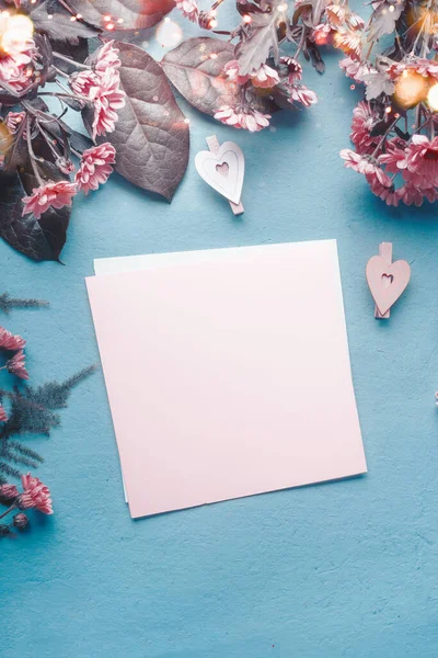 蓝色桌子上的空白贺卡 上面有粉红色的花和心 问候语的概念 母亲节 生日模拟了 复制空间 — 图库照片