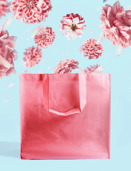 粉红购物袋 带着飘扬的花朵 衬托着淡蓝色的墙壁背景 品牌模仿了起来 复制空间 创意夏季概念 — 图库照片
