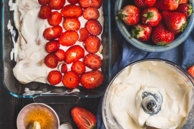 Çilekli tatlı. Dilimlenmiş böğürtlen tabağı ve koyu kırsal arka planda krema.