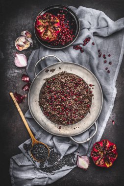 Sağlıklı vejetaryen siyah mercimek salatasının en üst görüntüsü. Nar ve koyu kırsal arka planda peçeteyle pişirilen malzemeler. Ülke koyu stili