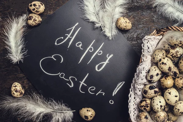 Happy Easter card with eggs and feathers in basket