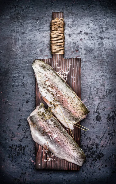 暗い素朴な背景に古い木のまな板上の2つの生の魚の切り身 トップビュー — ストック写真
