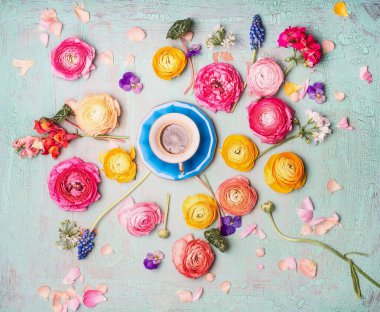 Turkuvaz rengi çiçekli bir fincan kahve. Mavi, pejmürde bir arka plan. Üst manzara, düz yatış.