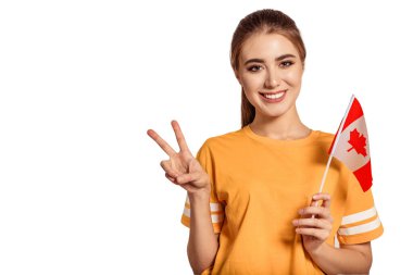 Güzel genç bir kadın elinde Kanada bayrağını tutuyor ve Victoria, Peace, Pacif işaretini gösteriyor. Değişim öğrencisi yabancı bir dil öğreniyor. Turist seyahati. Beyaz arka plan. İzole et