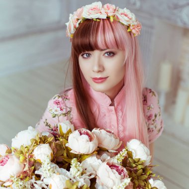 Pembe elbiseli güzel bir kadın, parlak bir odada ve çiçekler içinde, Lolita. Japon sokak modası. Portre.