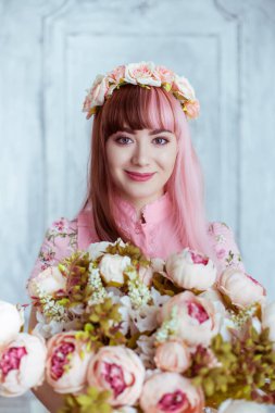 Pembe elbiseli güzel bir kadın, parlak bir odada ve çiçekler içinde, Lolita. Japon sokak modası. Portre.