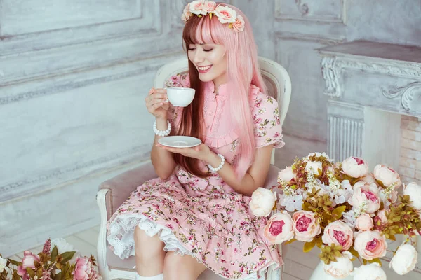 Молодая Женщина Розовом Платье Яркой Комнате Цветах Сидящая Кресле Чашкой — стоковое фото