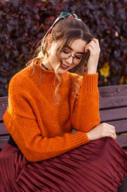 Ekim ayında güzel, genç bir kadın sonbaharda bir bankta oturur. Kız yuvarlak giyinmiş, cam gözlüklerle. Öğrenci öğretmen dinleniyor, parkta yürüyor..