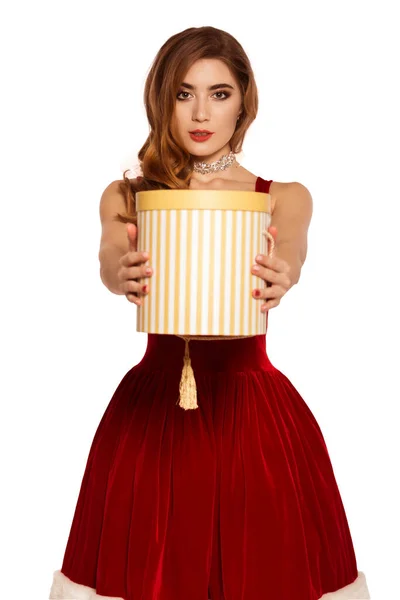 赤いドレスを着た美しい女性 サンタの助手だクラウスさん コスチュームパーティー 白地を隔離しろ プレゼントを受け取って好奇心驚き — ストック写真