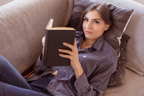 Hermosa Mujer Morena Sentada Sofá Con Libro Jeans Camisa Mujer — Foto de Stock