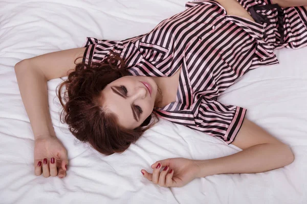 Красива Сексуальна Гаряча Дівчина Смугастій Атласною Піжамі Лежить Білому Ліжку — стокове фото