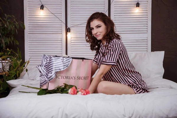 サマラ ロシア 2019年3月 女性がピンクのパケットを開きますバラの花束と白いベッドの上にビクトリアの秘密のスタンド — ストック写真