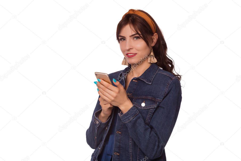 Beautiful brunette woman dressed in a blue jumpsuit and denim jacket. Chelma on the head. Modern look, fashion 2020.