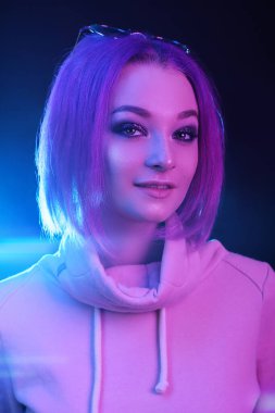Neon ışıkta mor saçlı genç bir kadının portresi. Gece hayatı. Y nesli, milenyum..