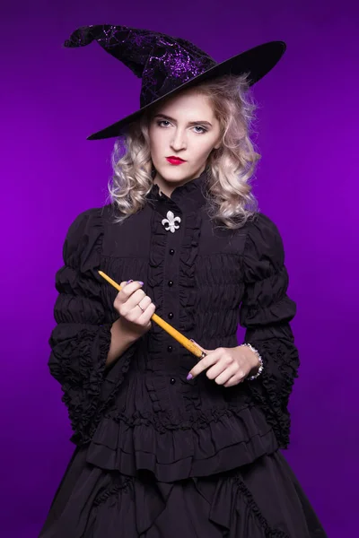 A strict, wicked teacher witch holds a pointer, a magic wand, on a purple background.