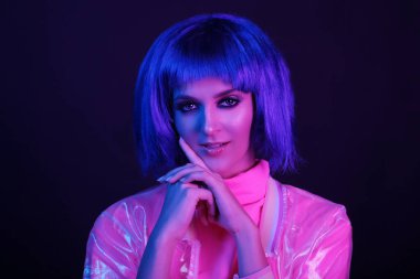 Neon light stüdyo yakın plan, peruklu mutlu kadın modelin portresi. Gece hayatı, gece kulübünde parti. Boşluğu kopyala.